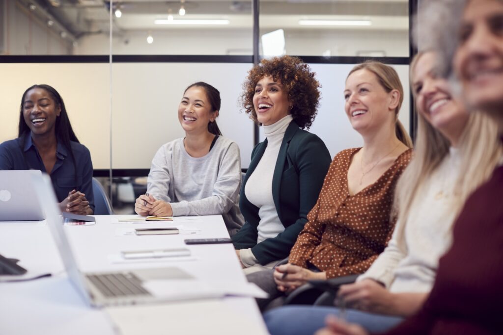 Women attending a meeting and listening to a presentation